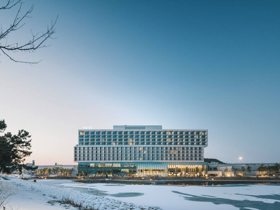 Un hotel moderno con una estructura rectangular, ventanas amplias y techo plano.