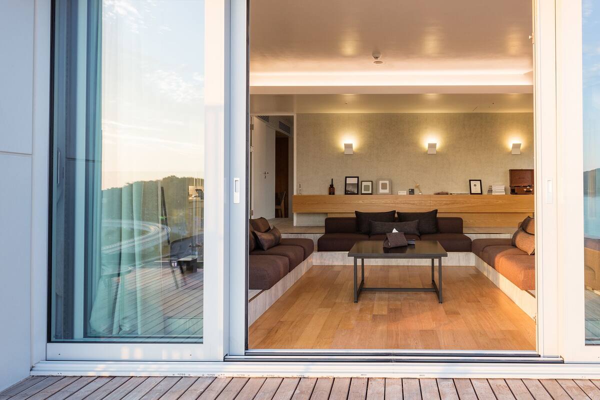 A modern living room with a sofa set, a coffee table, and wall-mounted lighting.