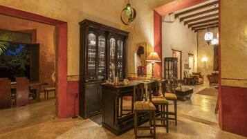 Un vestíbulo espacioso con zona de bar, muebles de madera y un gran aparador.