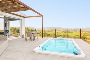 A modern outdoor pool area with a hot tub, a dining table, and chairs, overlooking a scenic landscape. - Cas Cabo Nou Agroturismo - Adults Only (Sant Llorenc des Cardassar)