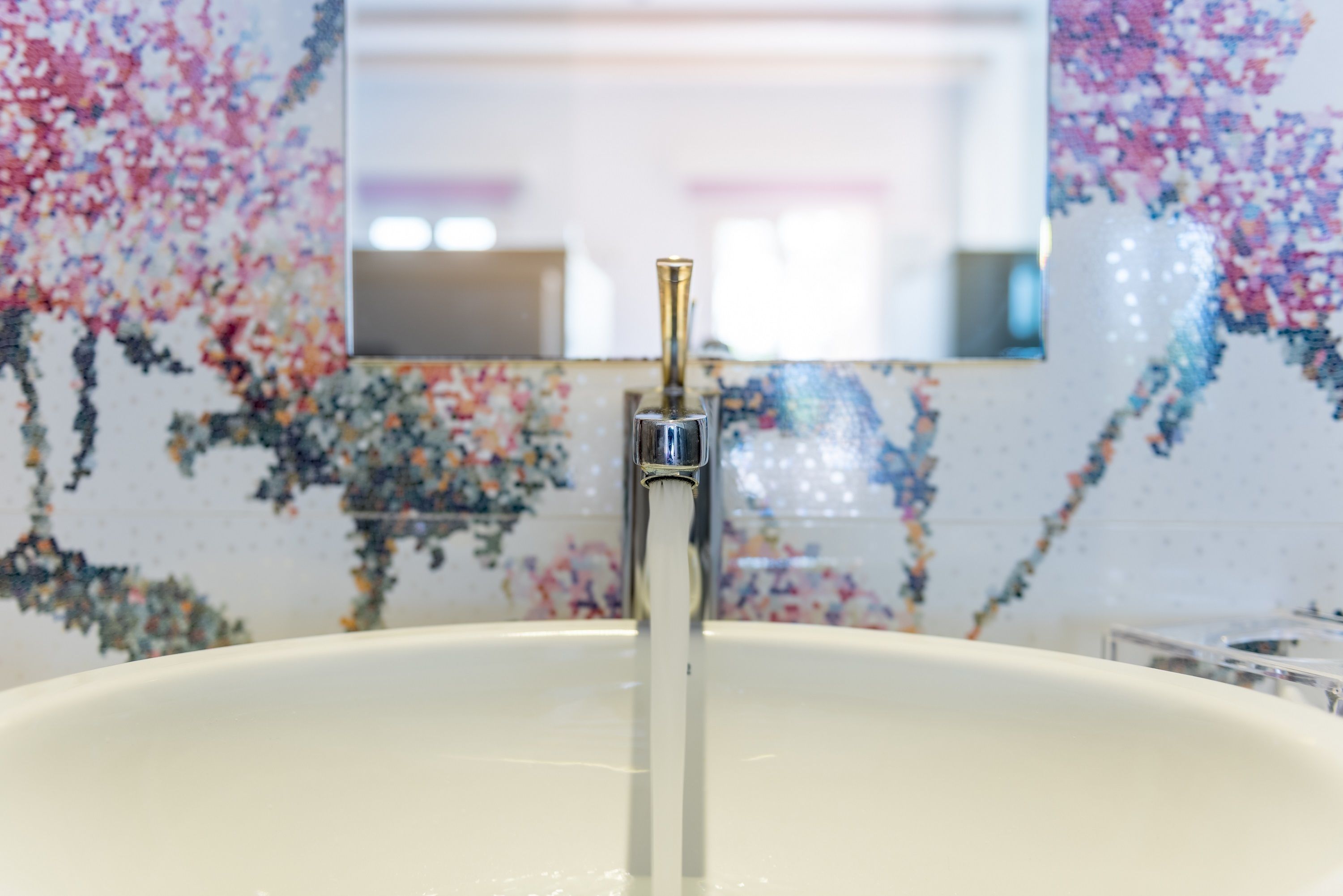 A bathroom sink with a faucet and a mirror above it.