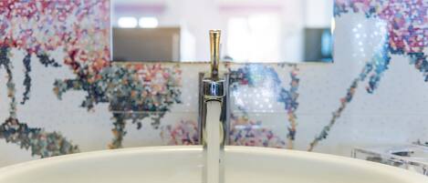 A bathroom sink with a faucet and a mirror above it.