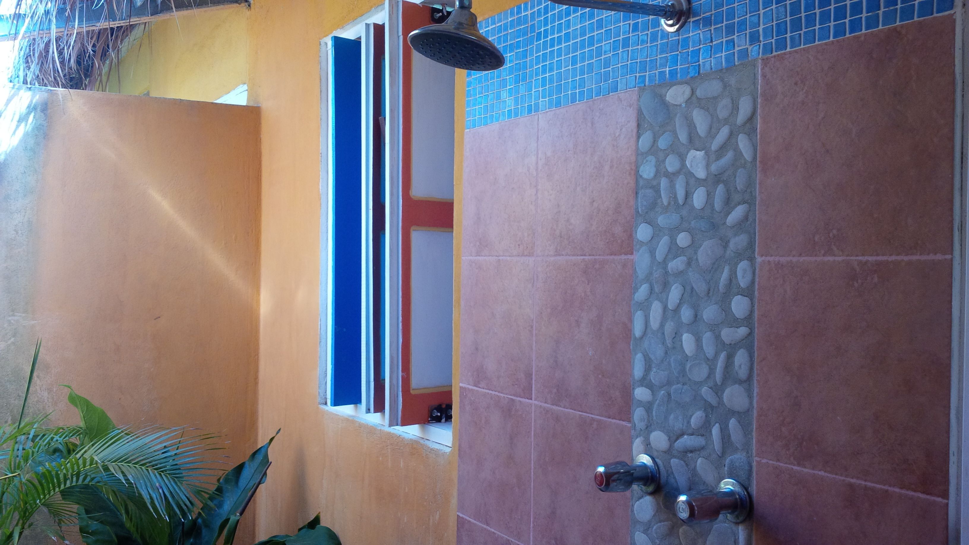 A bathroom with a shower, tiled walls, and a window.