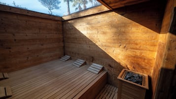 A wooden sauna with benches and a stone container.