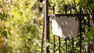 A sign with the name "LADY RINTHUS" on a metal gate surrounded by greenery.