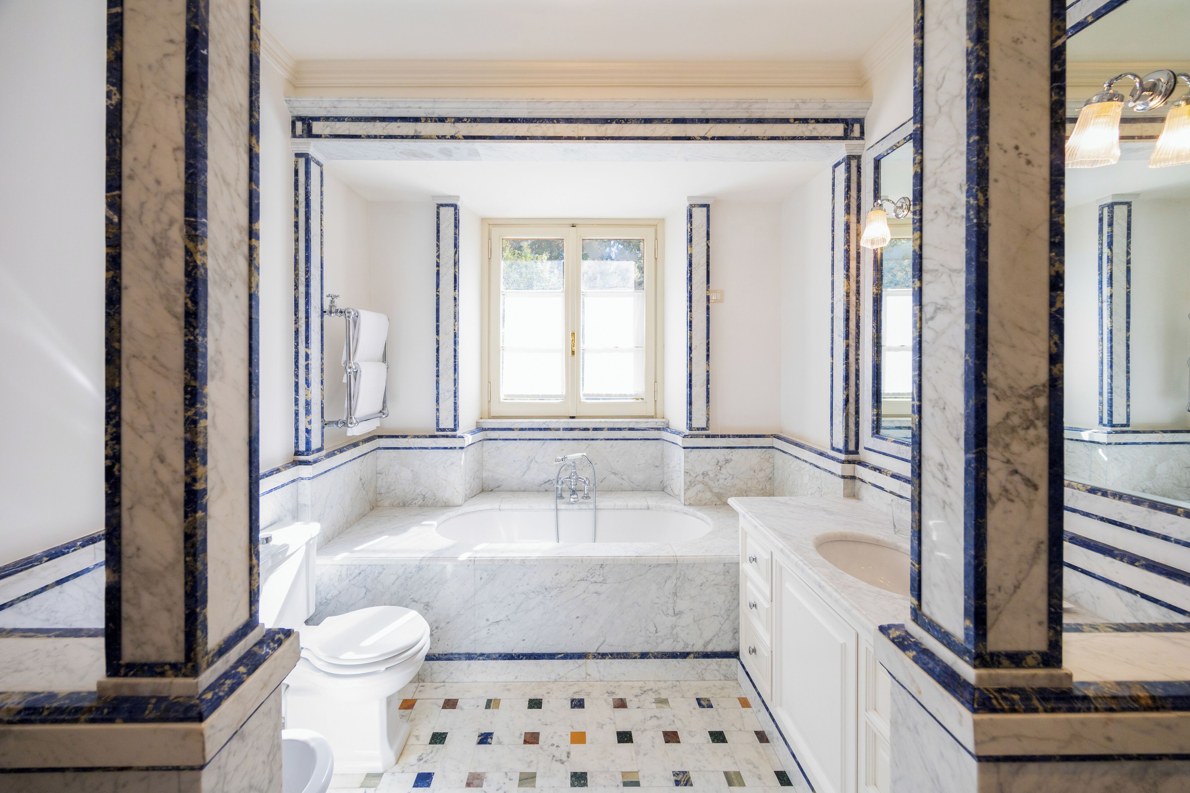 A bathroom with a large bathtub, a toilet, and a sink.