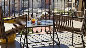 Varanda com mesa e cadeiras, com vista para a cidade.