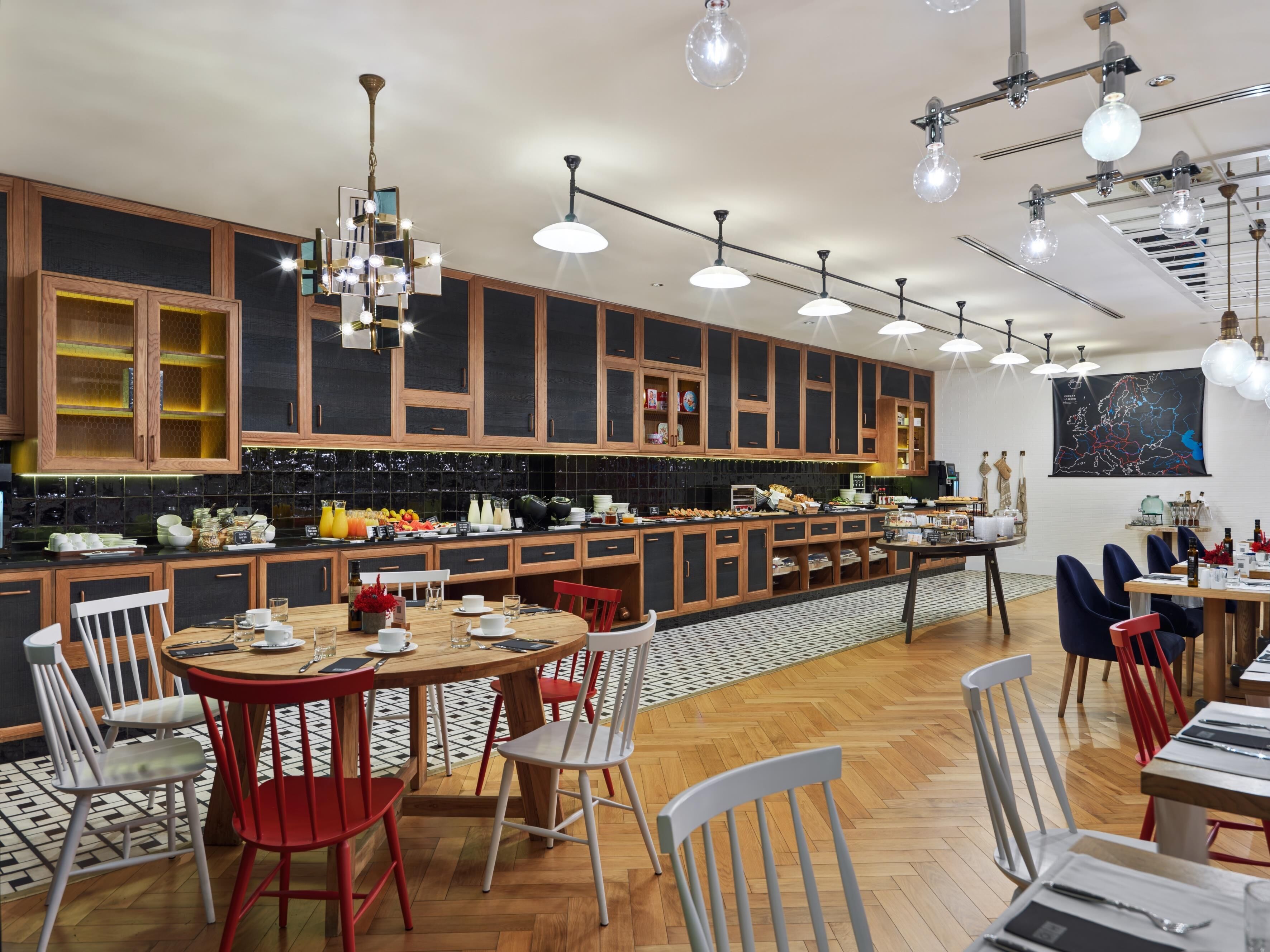 A modern kitchen with wooden cabinets, a central island, and pendant lighting.