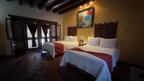 A hotel room with two beds, a large painting on the wall, and a window with shutters. - Hotel Boutique La Joyita (Cuernavaca)