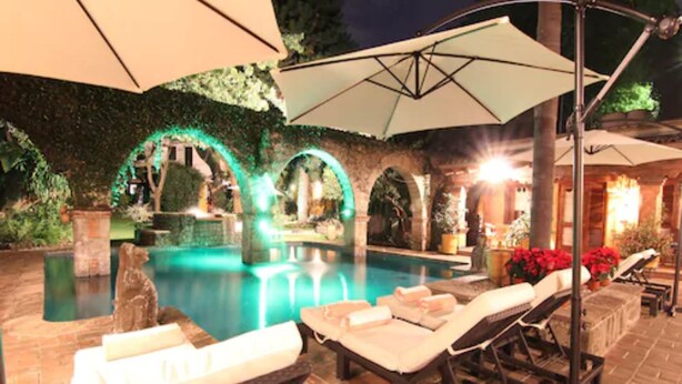 A poolside area with lounge chairs, umbrellas, and a stone pathway. - Hotel Boutique La Joyita (Cuernavaca)