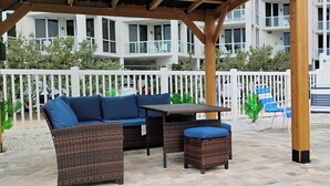 An outdoor patio with wicker furniture, a table, and chairs.