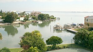 A marina with boats docked, a large building, and a city skyline in the background.