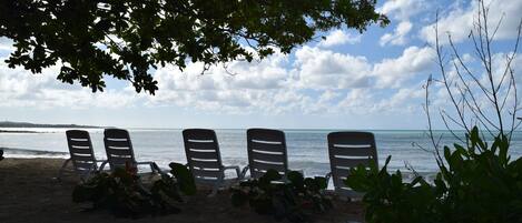 En la playa, sillas reclinables de playa, kayak