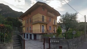 Un immeuble à plusieurs étages doté de balcons, d’une entrée sécurisée et surplombant un paysage montagneux.