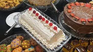 A buffet table with various desserts, including cakes, cookies, and pastries.