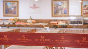 A buffet area with multiple food stations and a red banner with the word "PROFISSIONALLE" repeated.