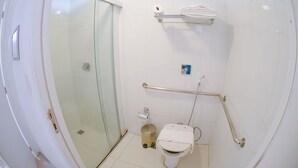 A modern bathroom with a glass shower enclosure, a white toilet with a grab bar, and a towel rack. - Profissionalle Hotel São Luís (São Luís)
