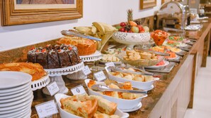 A buffet with various food items and labeled dishes. - Profissionalle Hotel São Luís (São Luís)