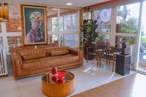 Un interior moderno con un sofá de cuero, una mesa de centro de madera y un ventanal con vistas al exterior.