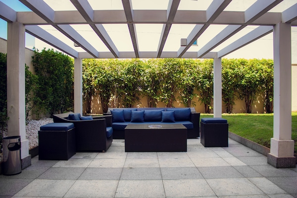 Una piscina al aire libre, sombrillas, sillones reclinables de piscina