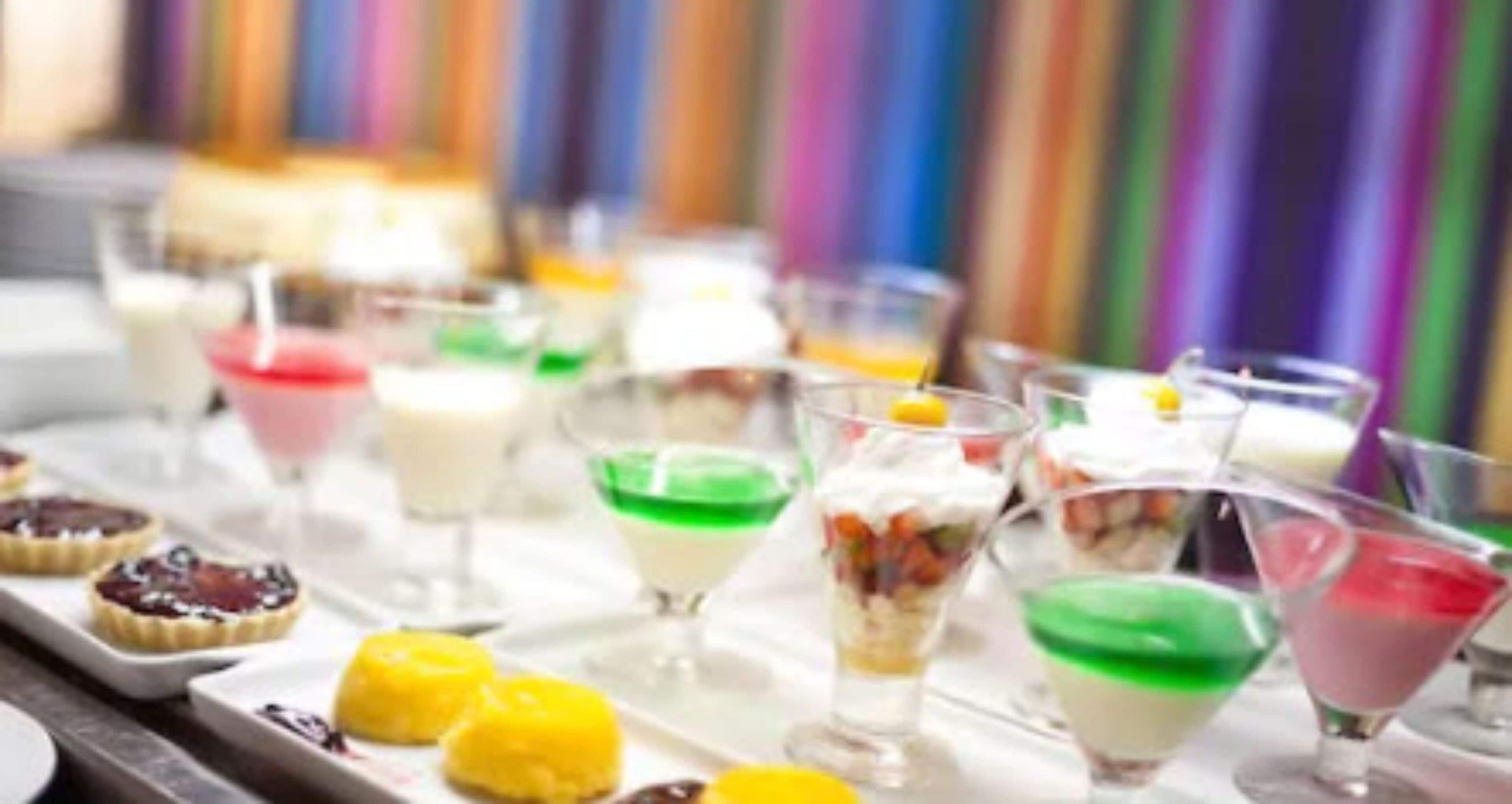 A variety of colorful desserts and drinks on a tray.