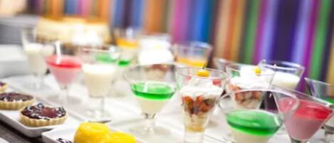 A variety of colorful desserts and drinks on a tray.