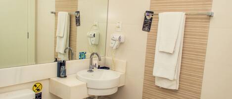 A bathroom with a sink, mirror, towel rack, and a toilet.