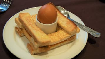 A plate with a sandwich and a boiled egg.