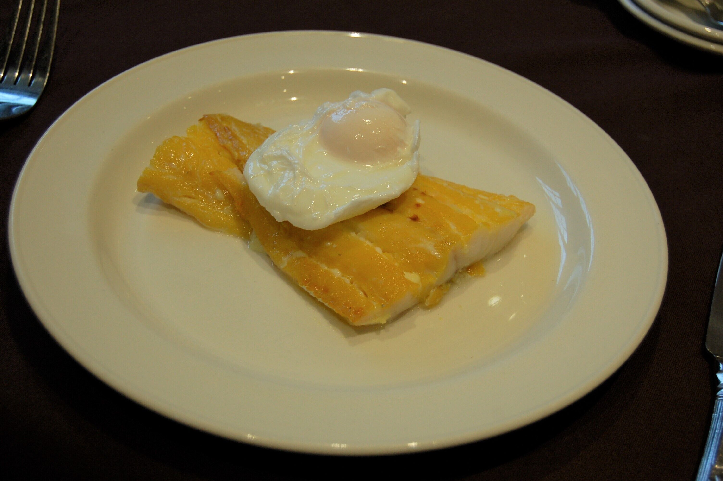 A plate with a fried egg on top of a piece of toast.