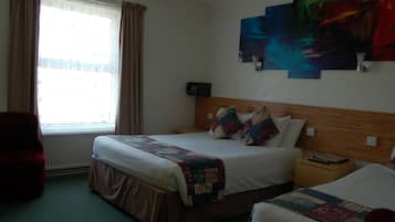 Una habitación de hotel con una cama grande, una cama más pequeña, una mesita de noche, una silla, un ventanal con cortinas y una obra de arte abstracta en la pared.
