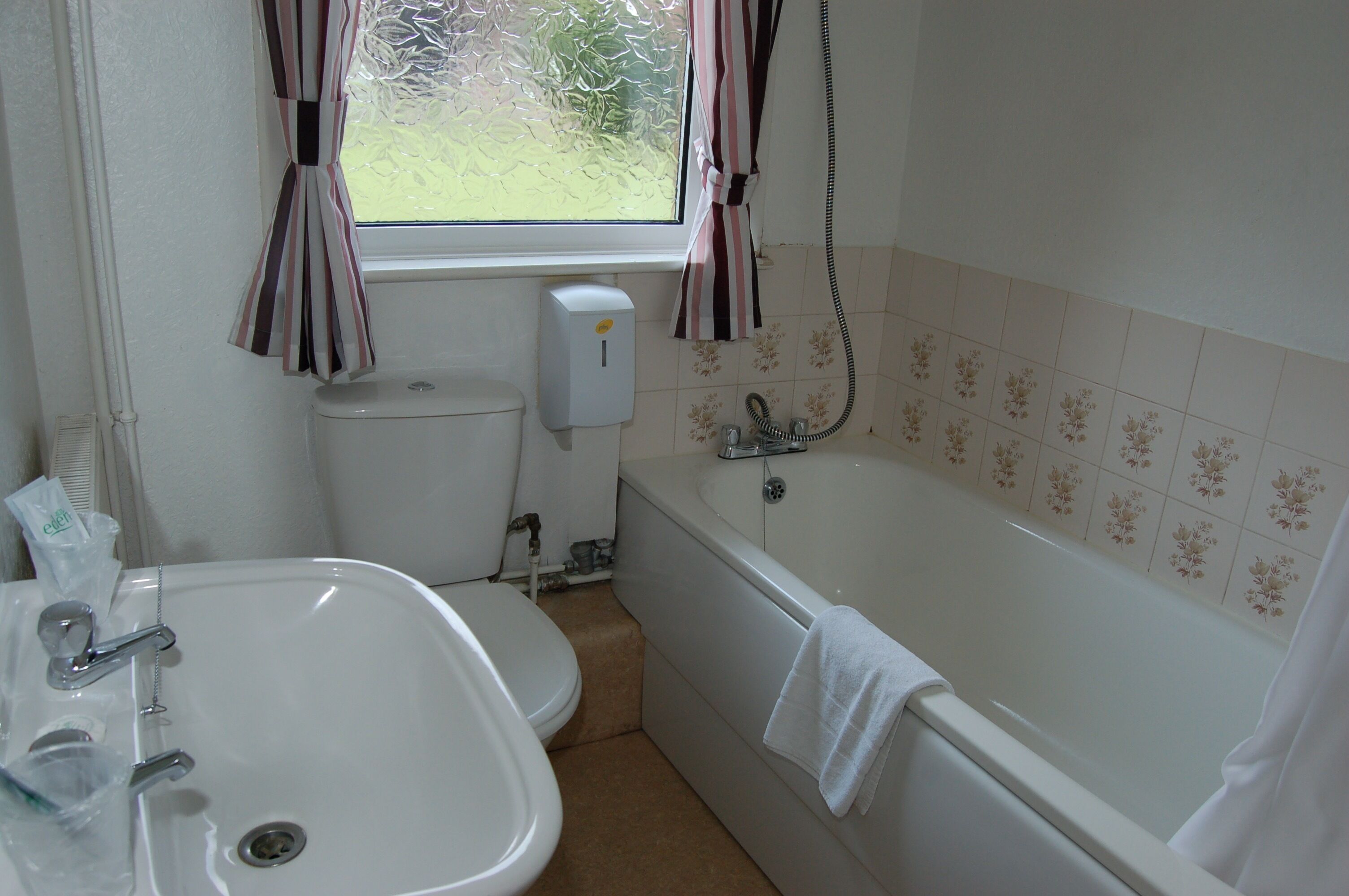 A bathroom with a toilet, sink, and bathtub.