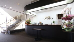 Una recepción de hotel con un diseño moderno, una escalera y vistas del interior.