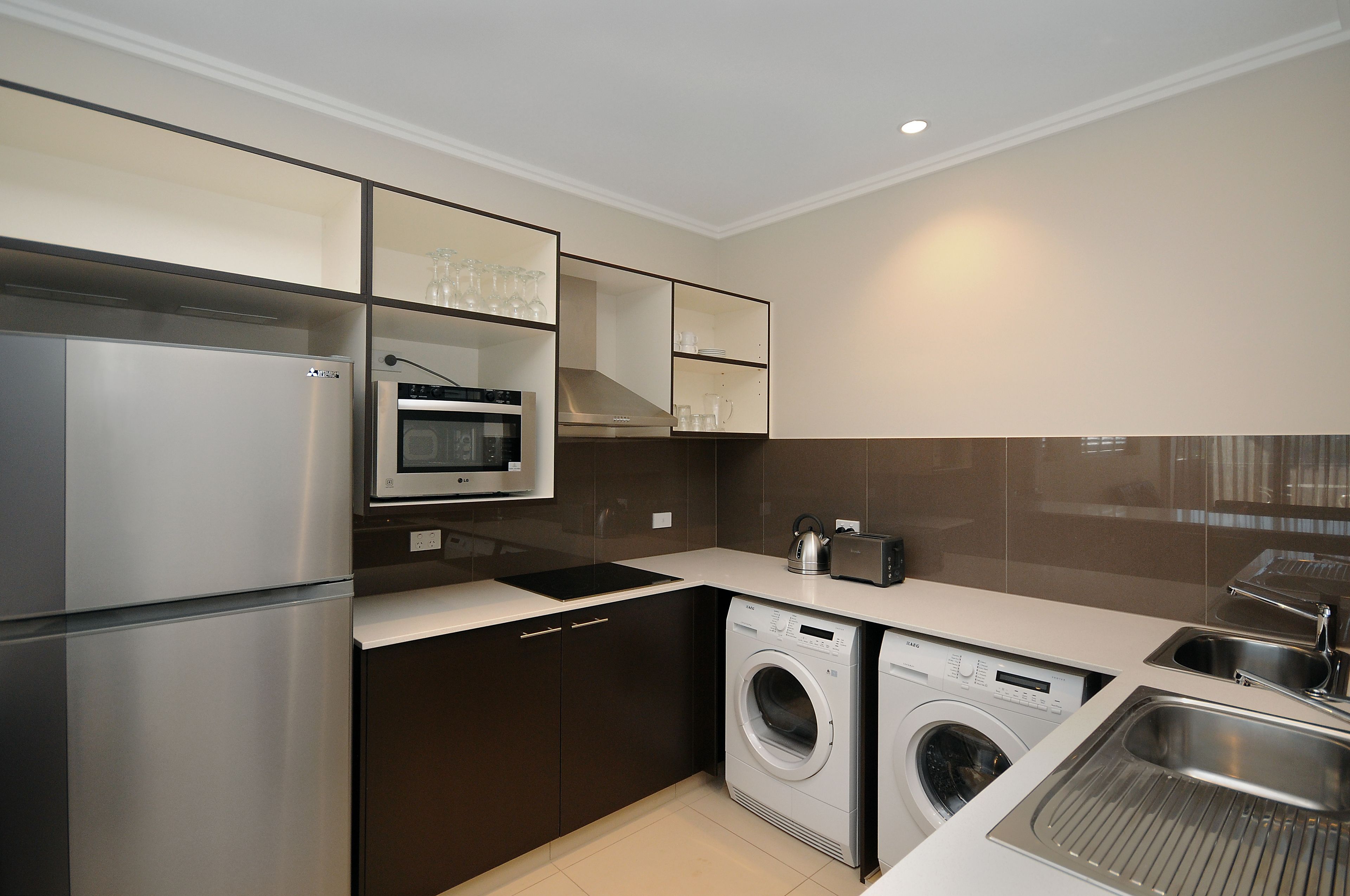 A modern kitchen with stainless steel appliances, a built-in oven, microwave, and a dishwasher.