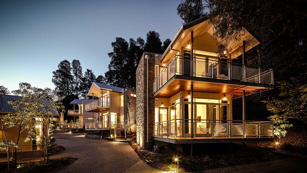 A modern multi-story building with balconies, large windows, and a pathway leading to the entrance. - Hepburn Spa Retreat (Hepburn Springs)