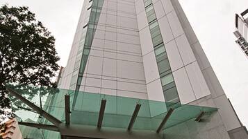 Un edificio alto y moderno con fachada de vidrio y una entrada destacada.