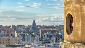 A cityscape with a prominent tower, a marina with boats, and a clear sky. - Bed & Breakfast Armonia (Syracuse)