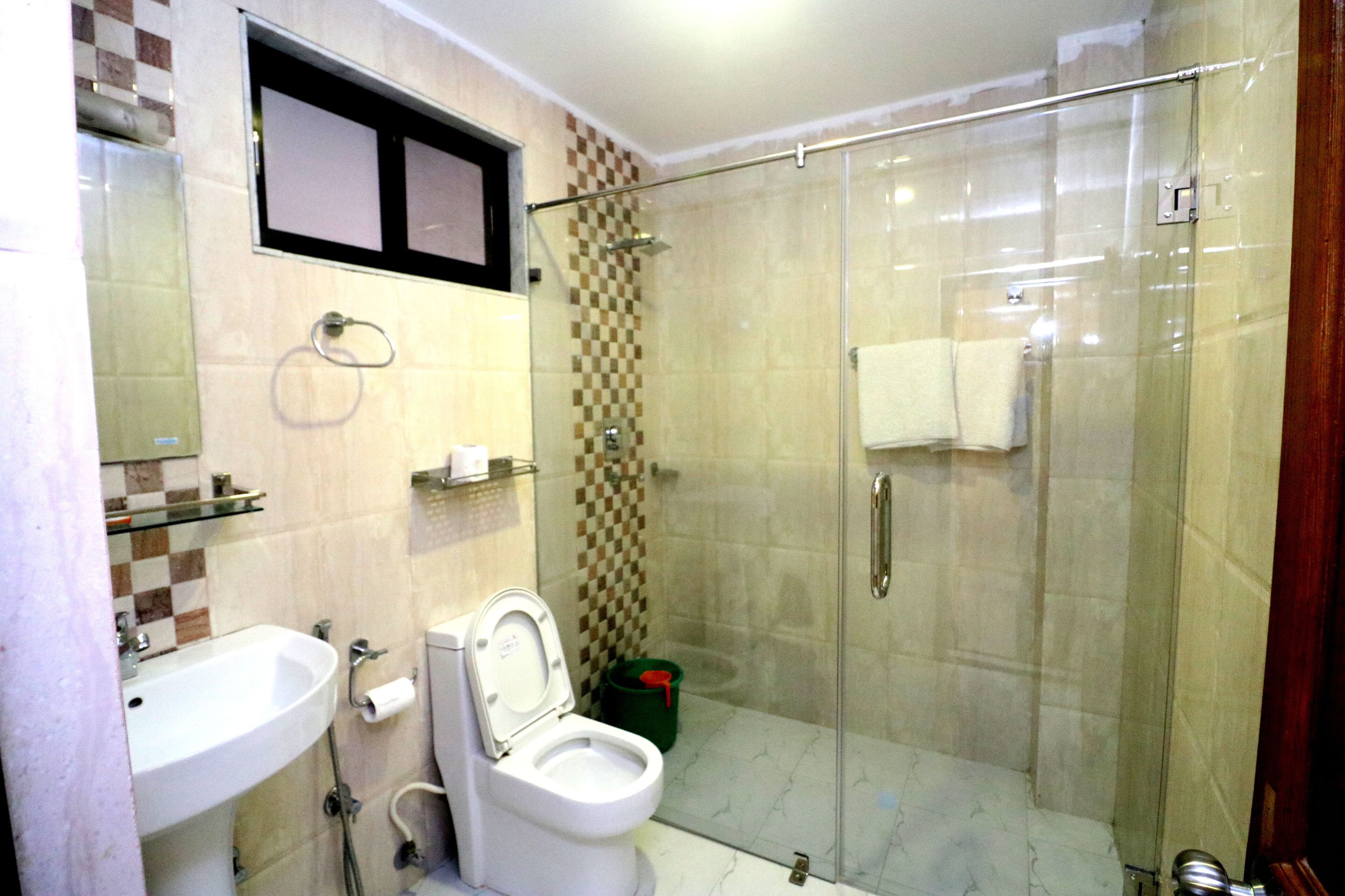 Un baño con ducha envuelta en cristal, un lavabo y un inodoro.