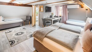 A cozy room with a bed, a desk, and a couch.