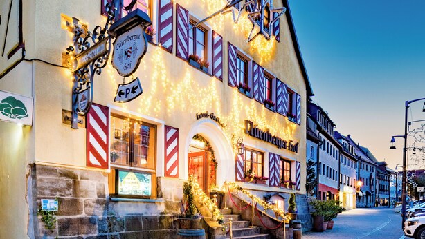 A traditional European building with a sign for "Turnierhaus" and "Platzgut".