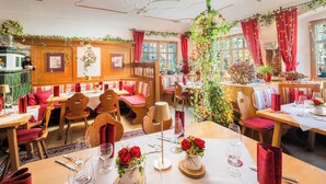 A restaurant with wooden booths, red cushions, and tables set for dining.