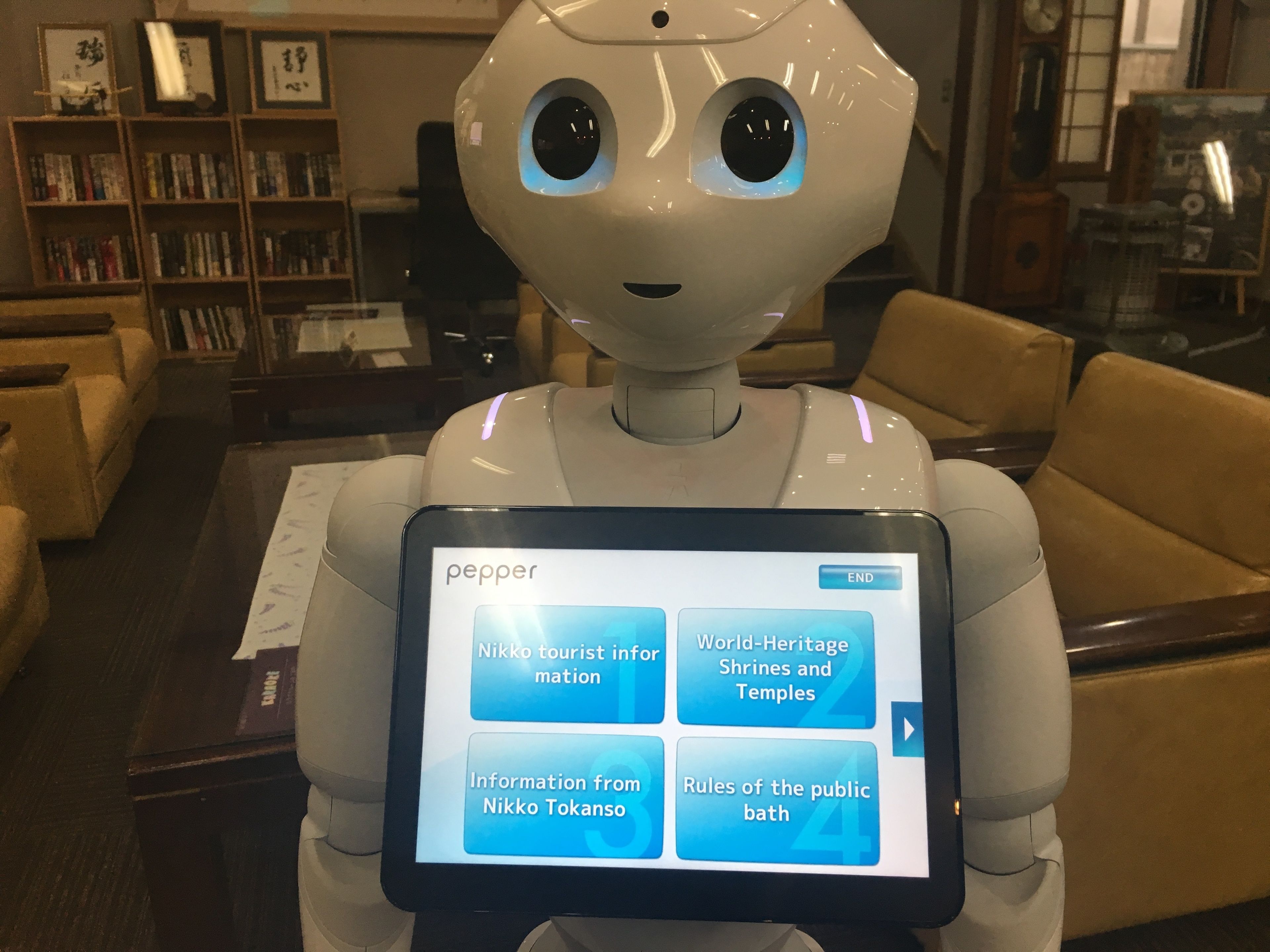 Un robot con una pantalla que muestra información sobre atracciones turísticas y normas para baños públicos.