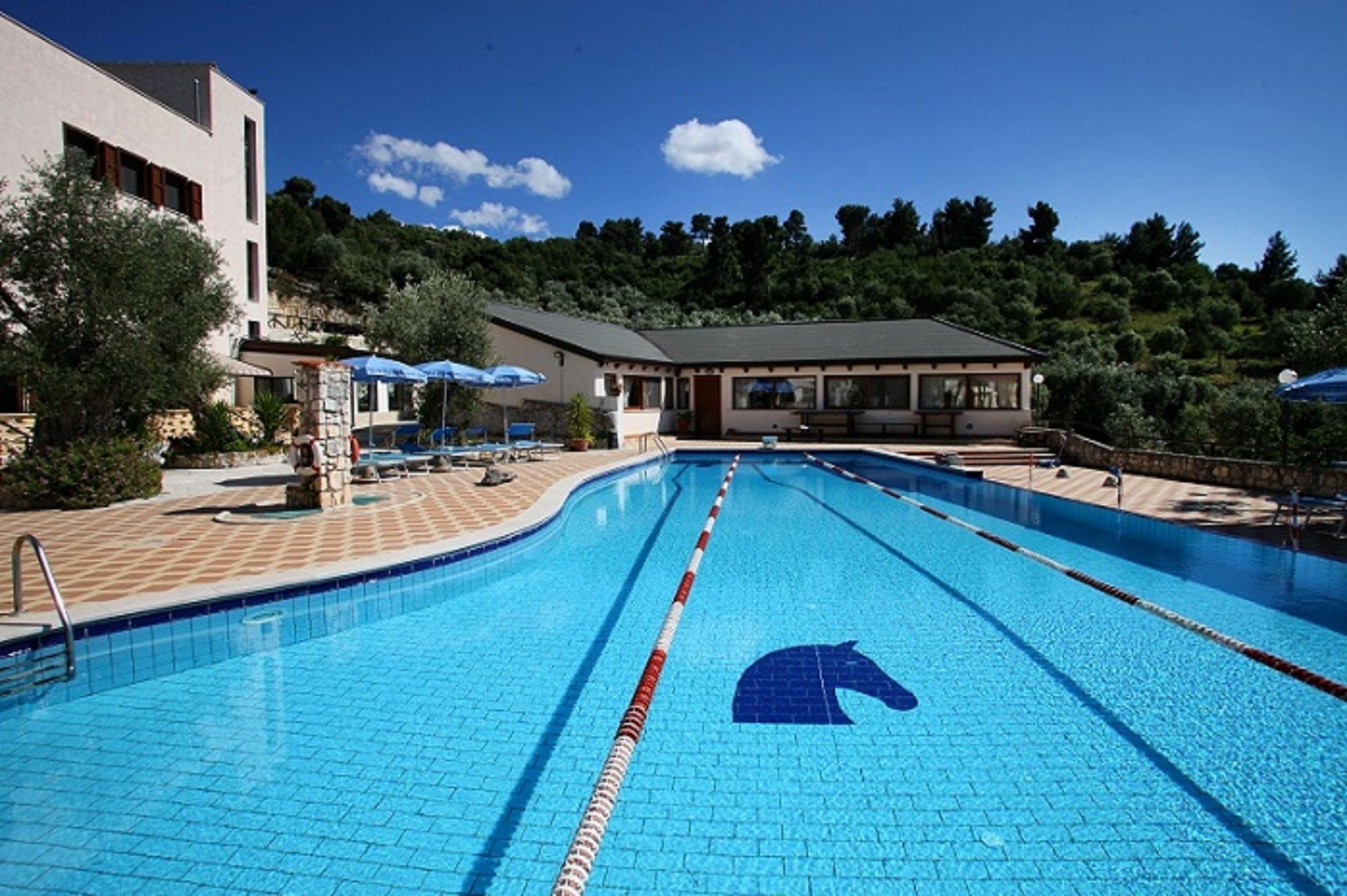 Piscina a l'aire lliure de temporada, para-sols i gandules 
