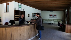 A reception area with a wooden reception desk, a couch, and a framed picture on the wall.