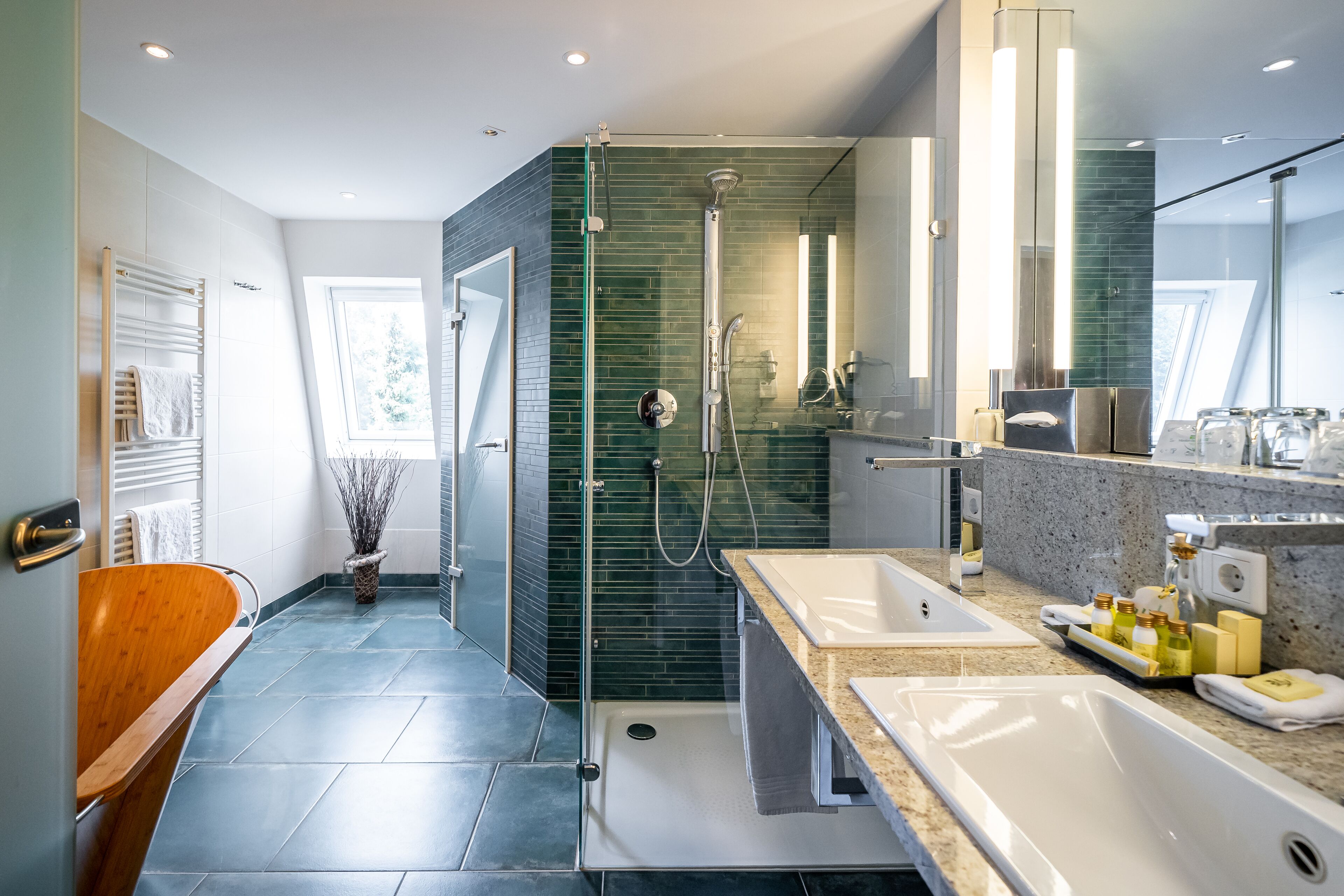 A modern bathroom with a glass-enclosed shower, two sinks, and a large mirror.