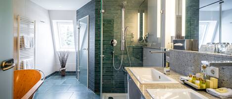 A modern bathroom with a glass-enclosed shower, two sinks, and a large mirror.