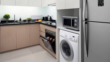 A modern kitchen with stainless steel appliances, wooden cabinets, and a tiled floor.