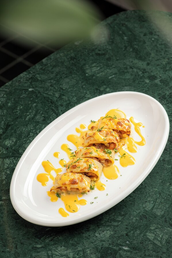 A white oval plate with food on a green marble table.