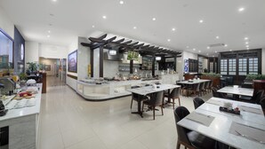 Un restaurante moderno con zona de bar, mesas y sillas.