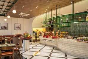 Un restaurante moderno con un sistema de buffet, zona de estar y exhibición de alimentos.