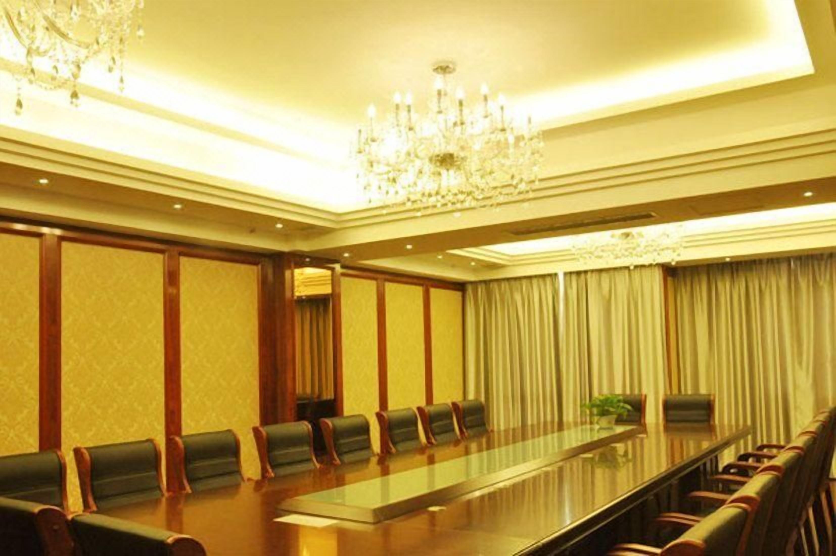 A conference room with a long table, chairs, and a chandelier.